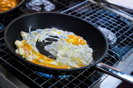 Fried eggs in pan in restaurant kitchen の写真素材