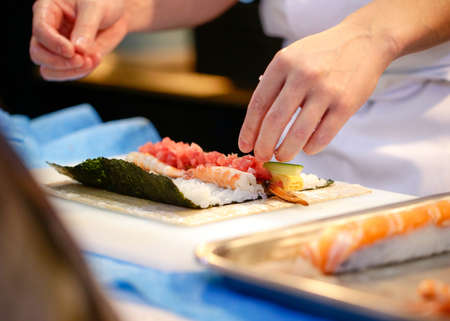 chef hands preparing japanese food, chef making sushi, Preparing Maki Sushi rollの写真素材