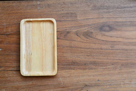 Wood dish on the wooden background. Top viewの写真素材