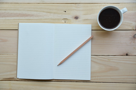 blank notebook with pencil and coffee pot on wooden table, business conceptの写真素材