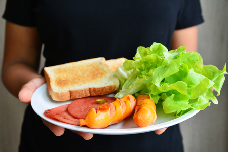 Breakfast sausage vegetable bread on white dishの写真素材