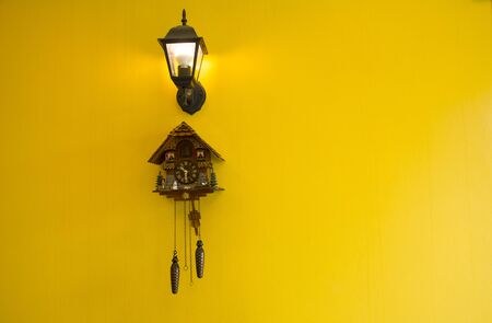 Wall clock with lamp On a yellow backgroundの写真素材