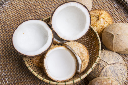 Open coconut with coconut peel on bamboo matの写真素材