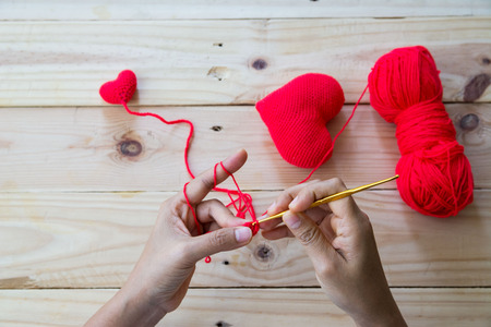 Handmade crochet red heart on wood background flat layoutの写真素材