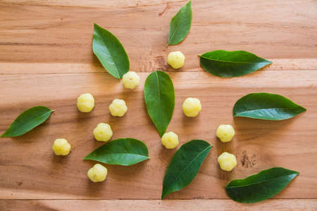Star gooseberry with green left on wood background