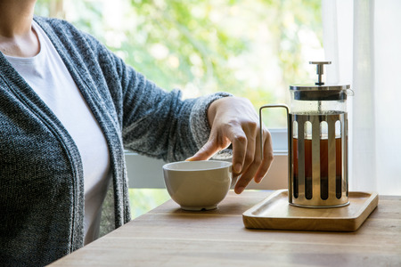 Women drinking coffee at relax time,french press with white cup on wood tableの写真素材