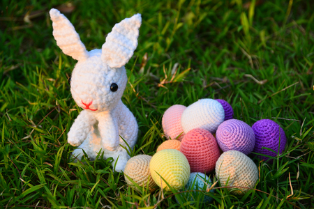 Knitting Easter eggs with rabbit on the grassの写真素材