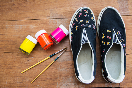 Hand made painted canvas shoes with acrylic pain and paintbrushの写真素材