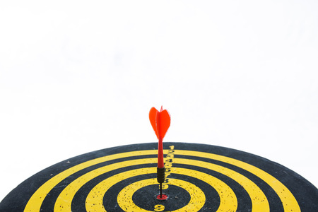 Red dart arrow on center of dartboard isolated on white background