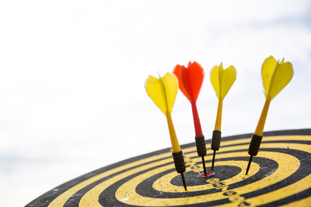 Red dart arrow on center of dartboard isolated on white background