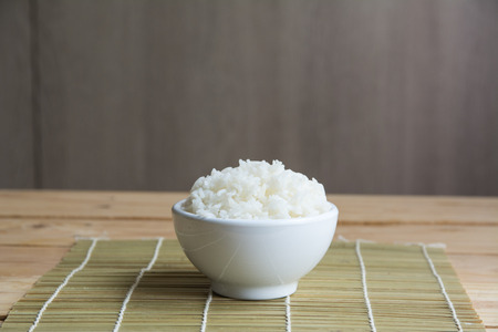 Jasmine rice in white cup On a bamboo matの写真素材