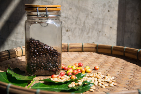 coffee bean in bottle with  cherry beans and coffee leavesの写真素材