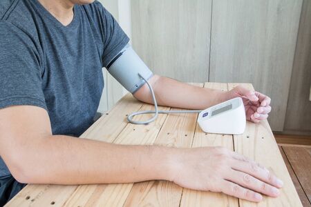 Men measures  blood pressure and heart rate with digital pressure gauge