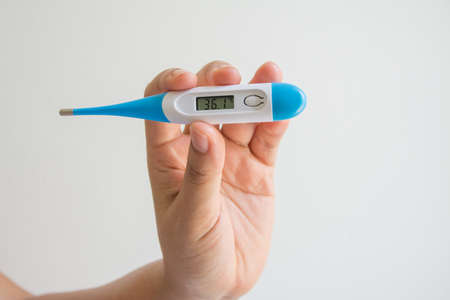 Women hands holding a digital thermometer