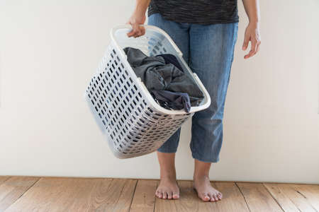 Women with laundry basket on floor and white backgroundの写真素材