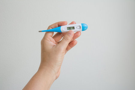 Women hands holding a digital thermometer
