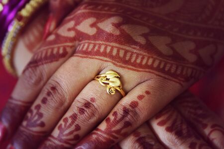Girl wearing her engagement ring in finger with full designed colour on her hands