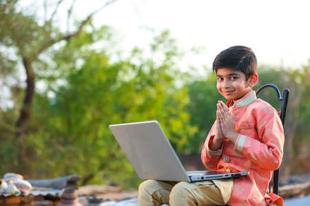 Indian child wearing traditional cloth and using laptopの写真素材
