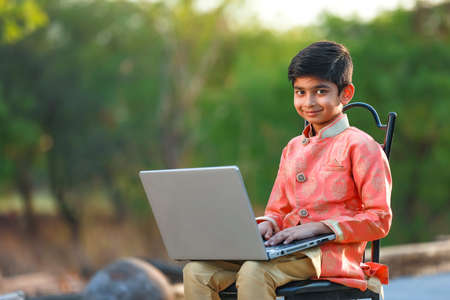 Indian child wearing traditional cloth and using laptopの写真素材