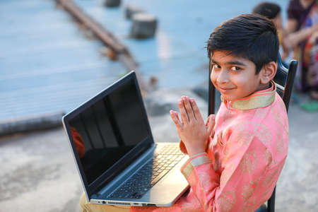 Indian child wearing traditional cloth and using laptopの写真素材