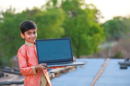 Indian child wearing traditional cloth and showing laptop screenの写真素材