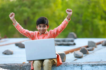 Excited Indian child with laptopの写真素材