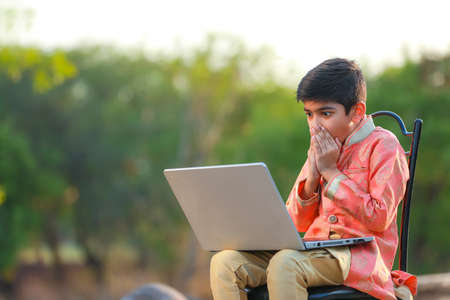 Indian child surprising on some good news in laptopの写真素材