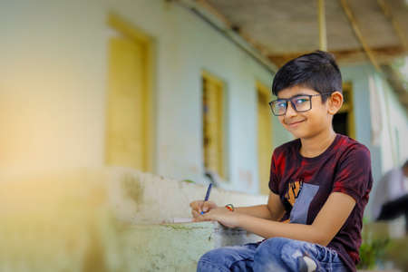 Indian little boy writing on note book