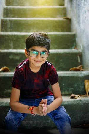 Indian / Asian Little boy studying online using mobile phone at homeの写真素材