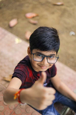 Indian child wearing spectacles and showing thumbs upの写真素材