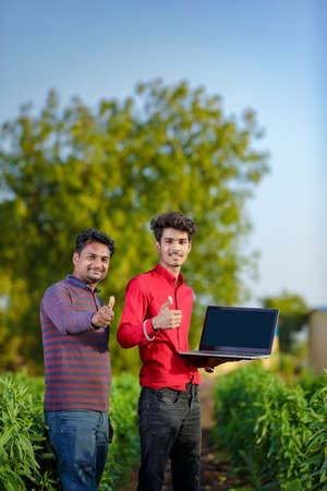 Young indian farmer with agronomist at fieldの写真素材