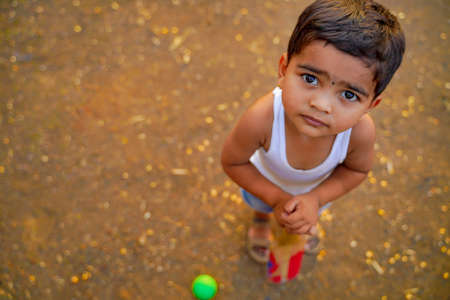 small indian child playing cricket at homeの写真素材
