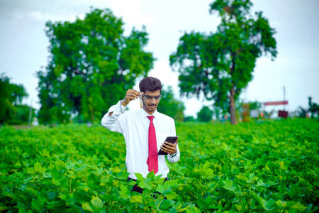 young indian handsome agronomist with test tube and tabletの写真素材