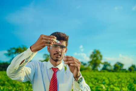 Young indian agronomist with test tube, Agriculture and scientist concept.の写真素材