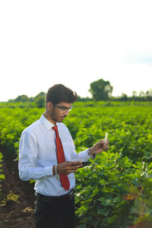 young indian handsome agronomist with test tube and tablet