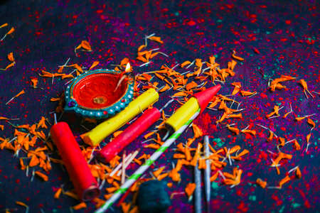 Diwali Diya with Fire Crackers over rangoli background