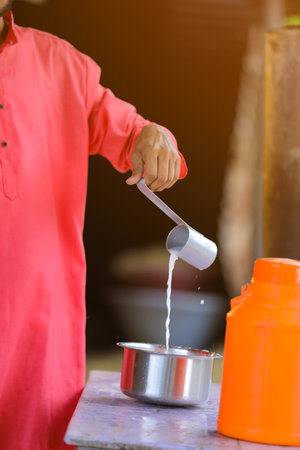 Indian farmer or milkman distribute milk at dairy farmの写真素材