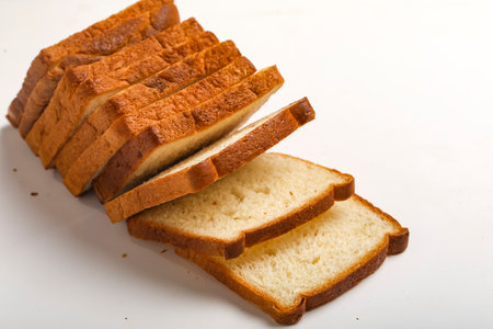 Cut of loaf bread on white against white background