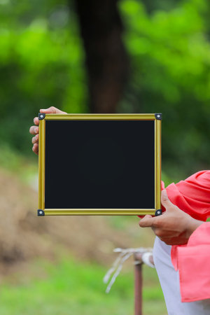 Holding black chalkboard in hand with copy spaceの写真素材