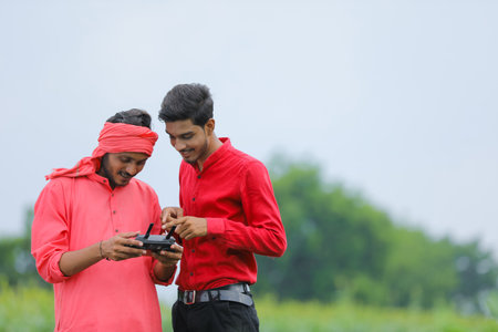 Indian farmer and agronomist using drone at agriculture field