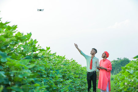 young indian agronomist and farmer using drone for checking at agriculture fieldの写真素材