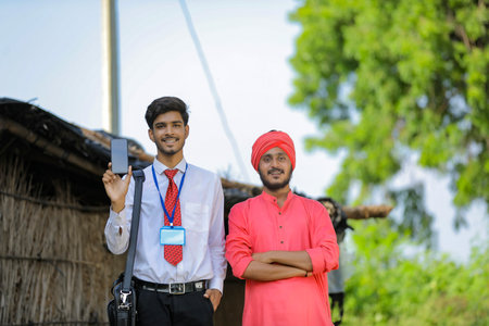 Young indian bank officer showing mobile screen with farmerの写真素材