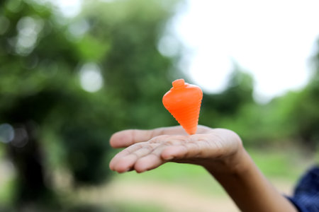 Cute indian little child playing Lattu, Bhovra or Bambaram is a traditional throwing top using...