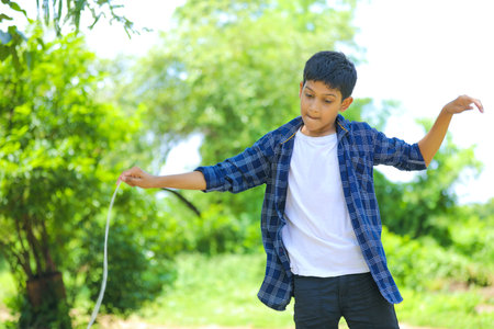 Cute indian little child playing Lattu, Bhovra or Bambaram is a traditional throwing top using thread, played mainly in Indiaの写真素材
