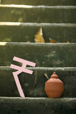 Indian rupees symbol and clay piggy bank