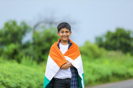 Cute little boy waving Indian National Tricolor Flag over nature backgroundの写真素材