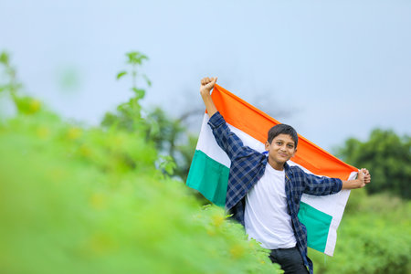 Cute little boy waving Indian National Tricolor Flag over nature backgroundの写真素材