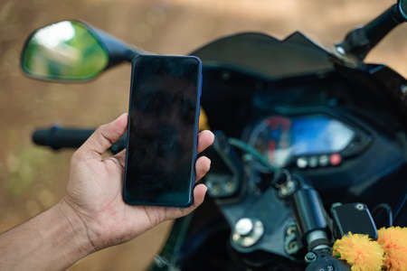 smartphone in hand with new bikeの写真素材