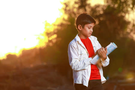 Indian Asian school boy with note book and studying at homeの写真素材