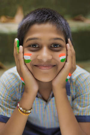 young indian child with indian flag on faceの写真素材